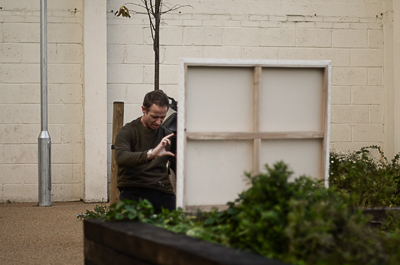 Jimmy C outside his studio, shooting his finished canvas