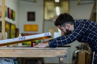 Beau Stanton preparing new handmade screen prints - marking the locations of the print to match the screen
