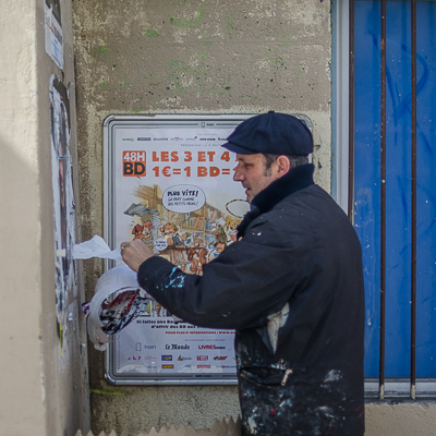 Wheatpasting in Paris - first, ripping off old posters and ads